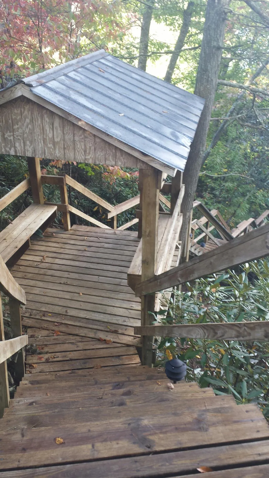 Metal roofed shelter over wooden steps on a wooded walkway — Skylight Repair & Installation work by our crew in Crooks